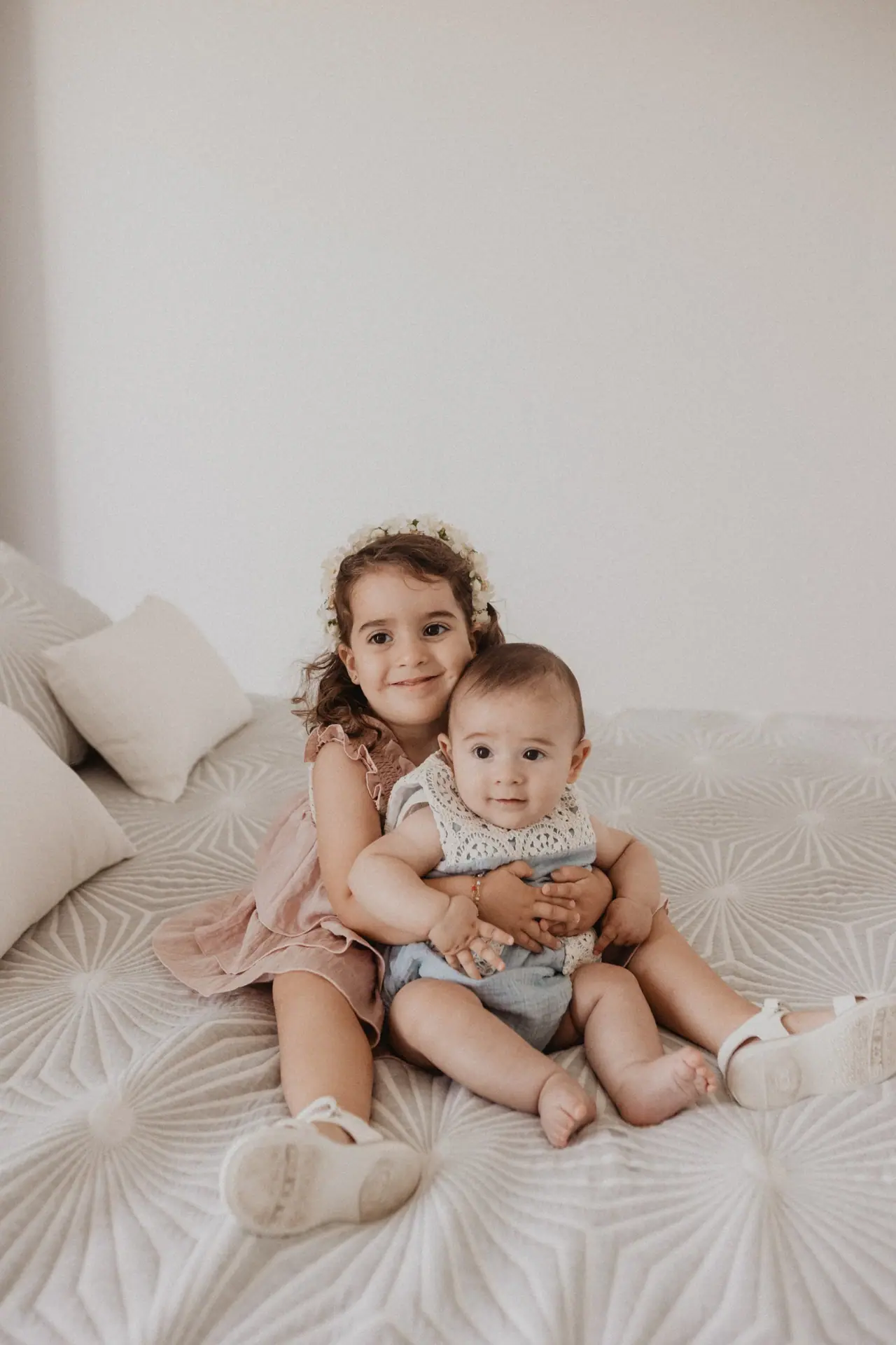 Fotografía de bautizo: hermanos cama estudio