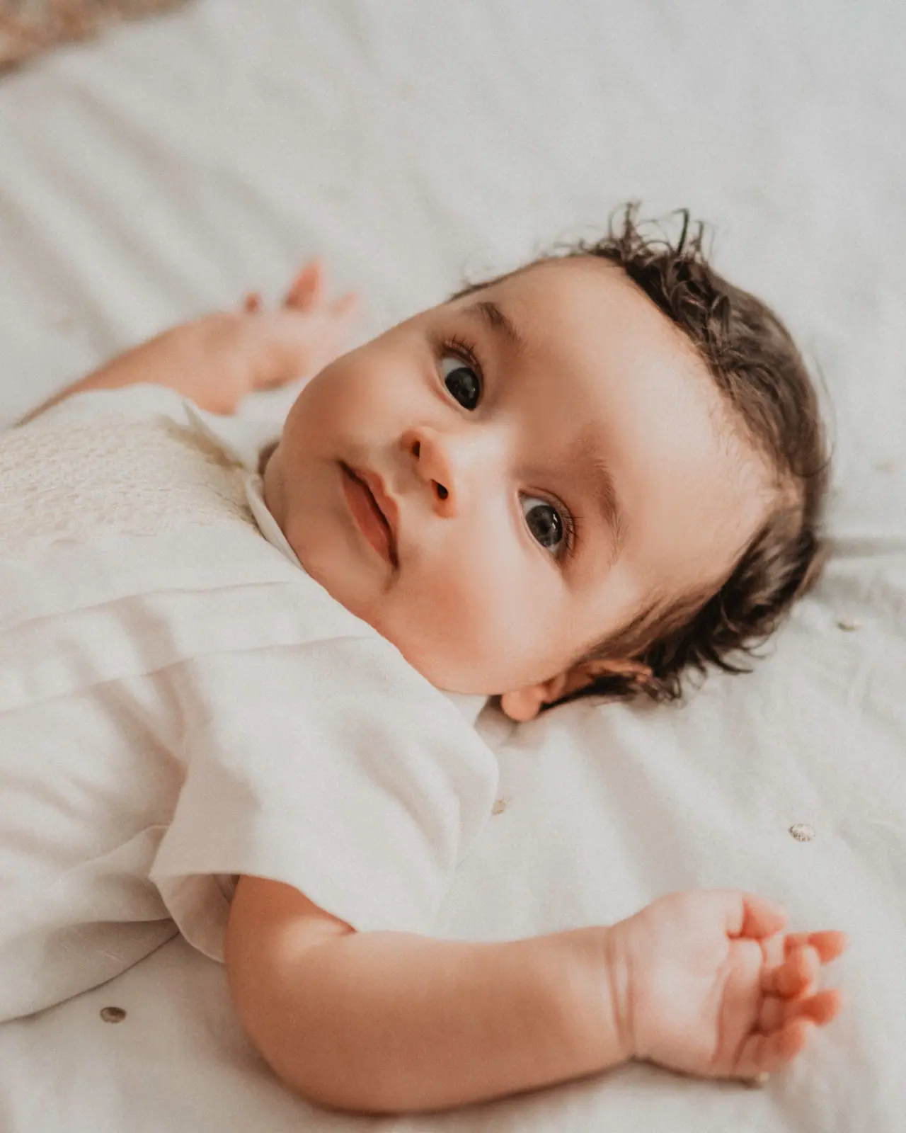 Fotografía de bautizo: bebe tumbado mirada