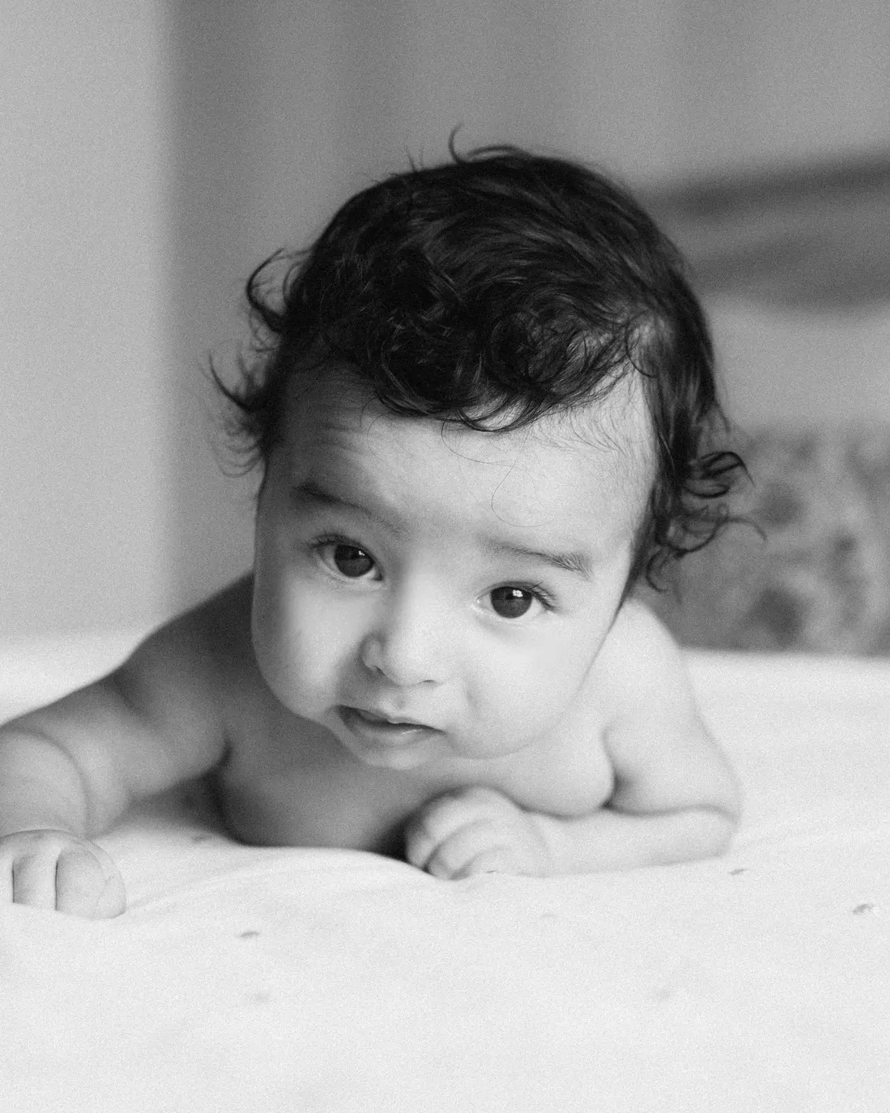 Fotografía de bautizo: bebe boca abajo, en blanco y negro