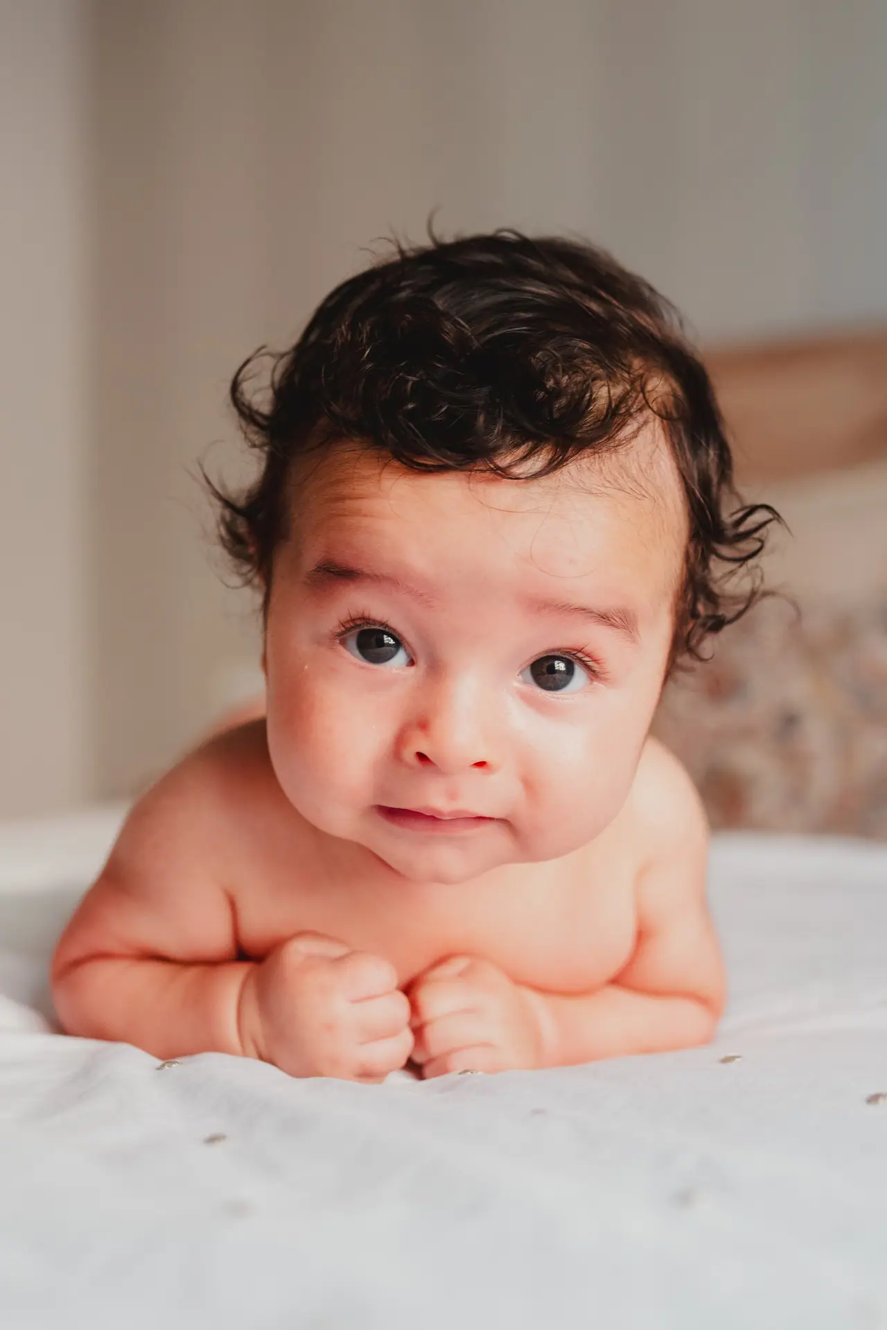 Fotografía de bautizo: bebe boca abajo sonrisa