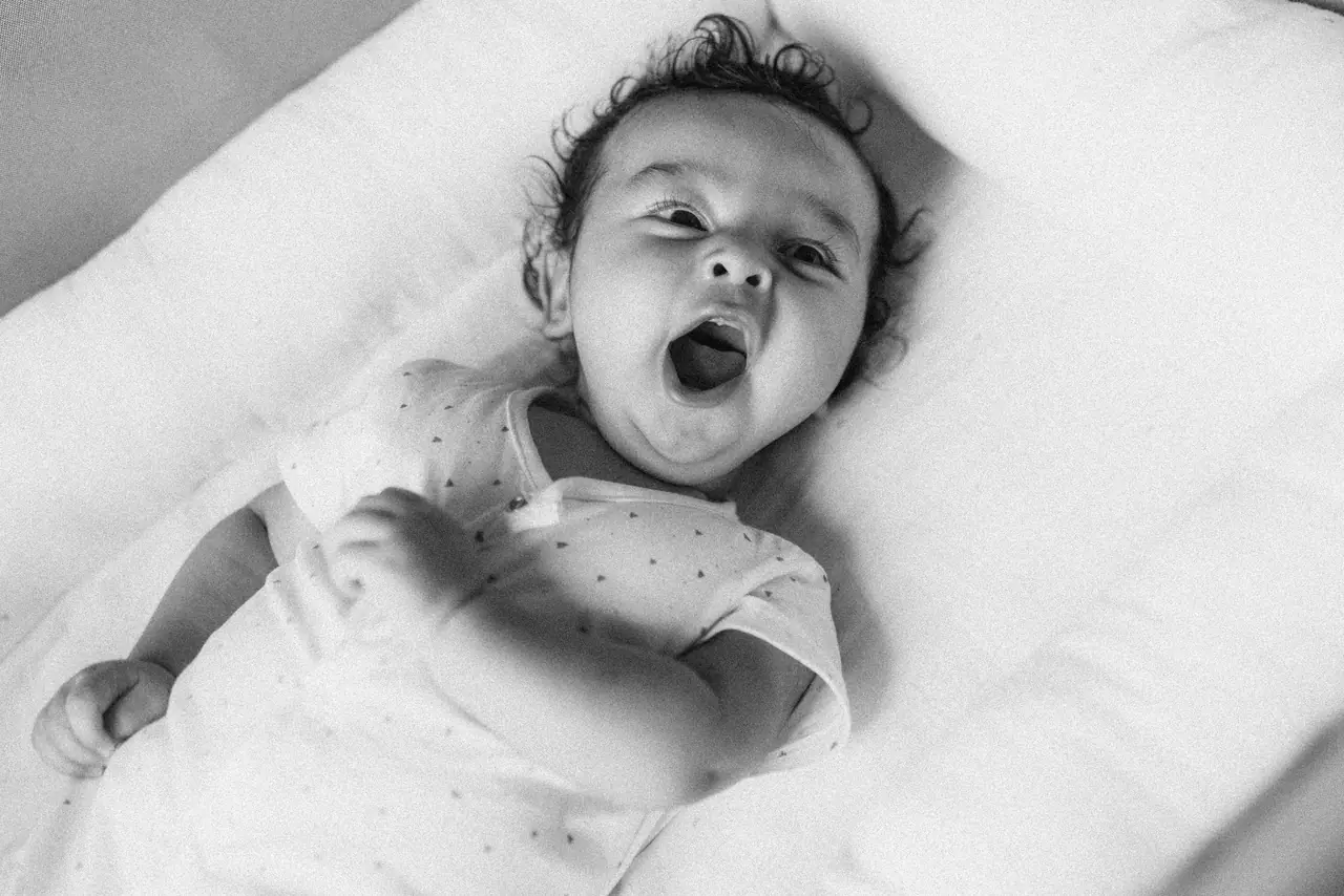 Fotografía de bautizo: bebe bostezo, en blanco y negro