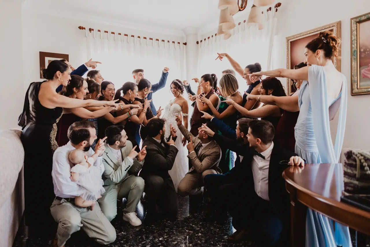 Fotografía de boda en Valencia: novia amigos señalando