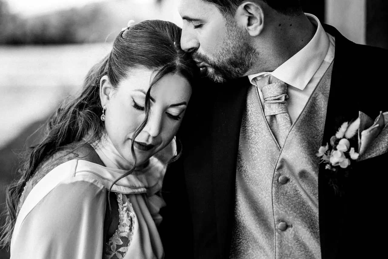 Fotografía de boda en Valencia: beso frente chaleco, en blanco y negro