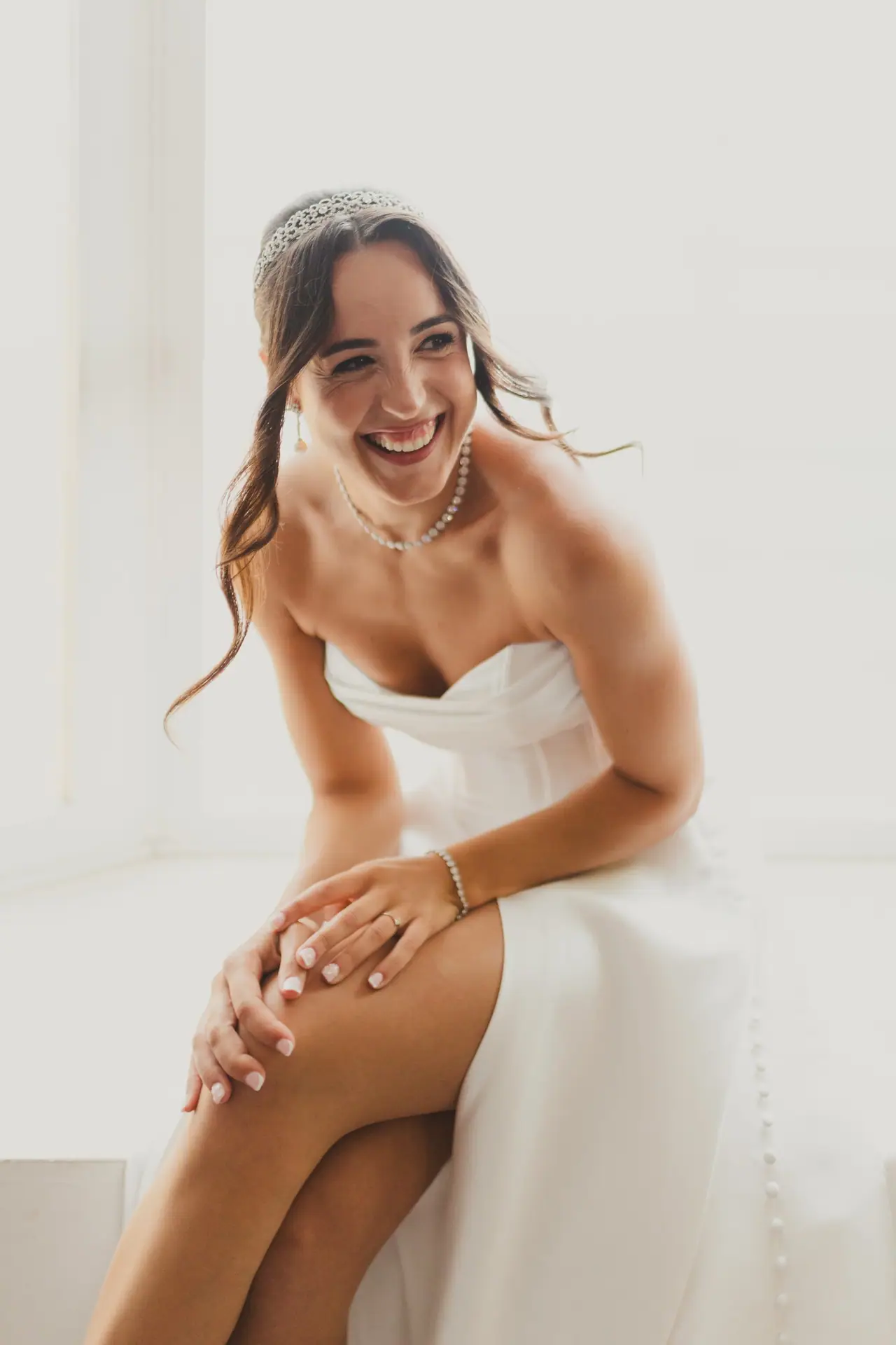 Fotografía de boda en Valencia: novia risa ventana tiara