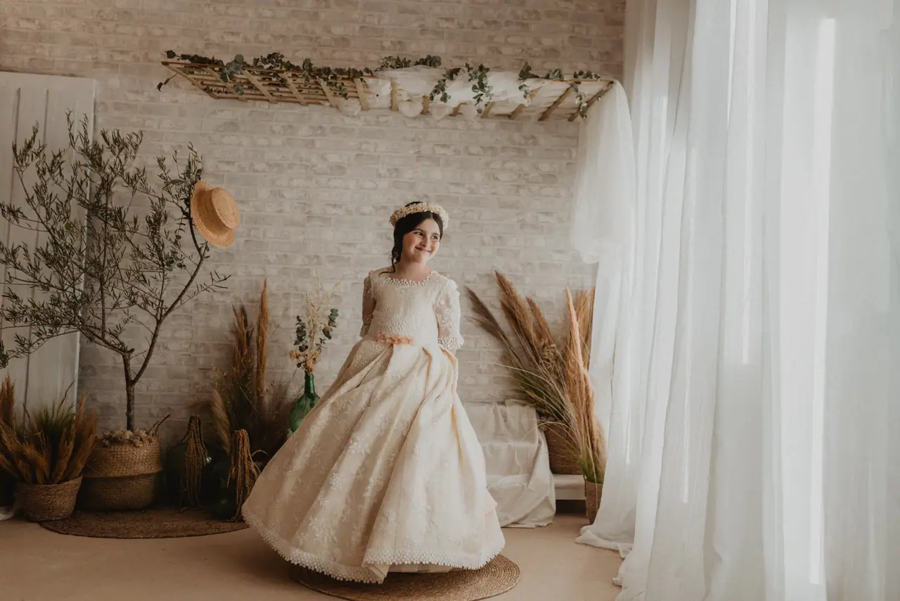 Niña con su vestido de comunión dando vueltas en el estudio