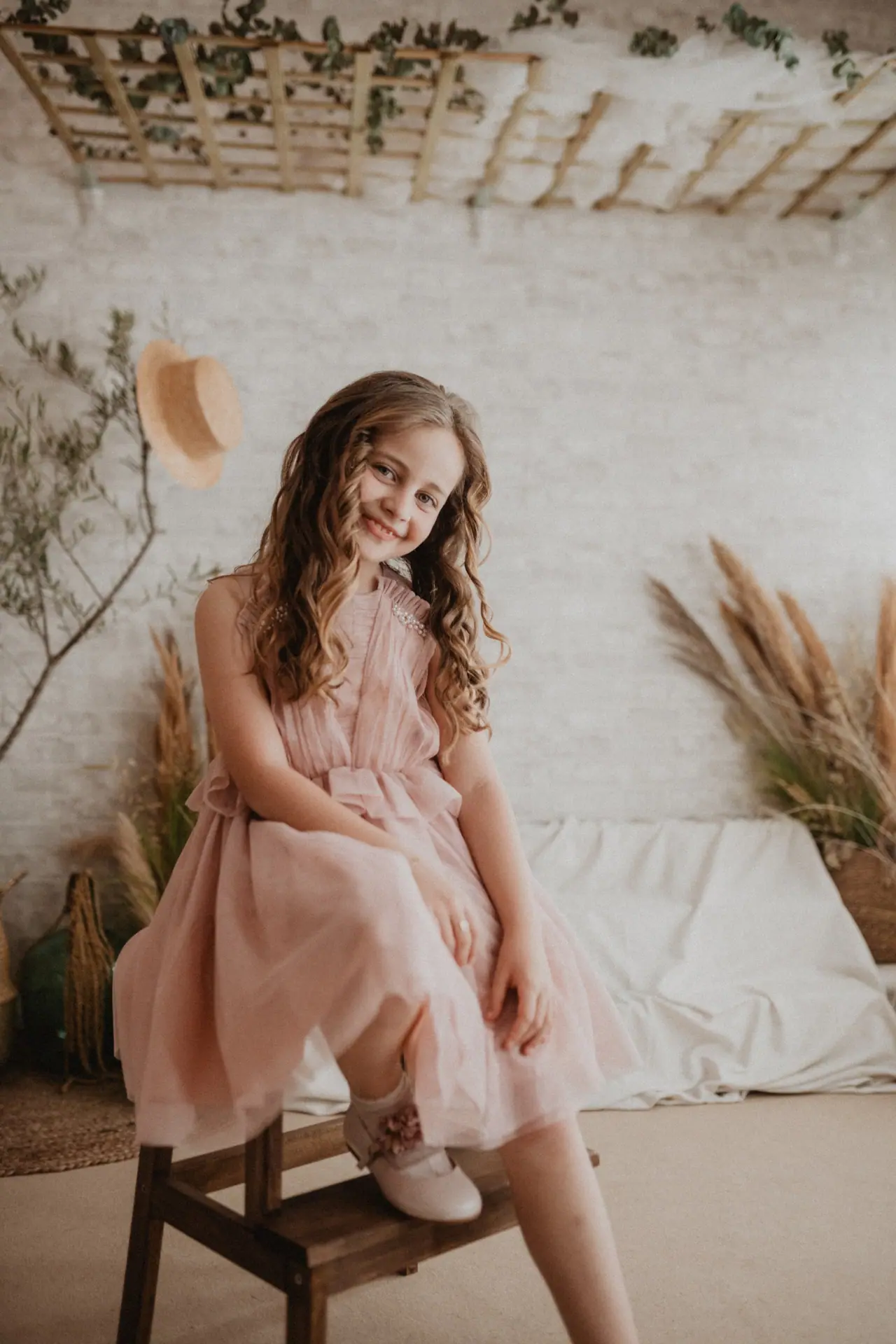 Fotografía de comunión: estudio vestido rosa taburete