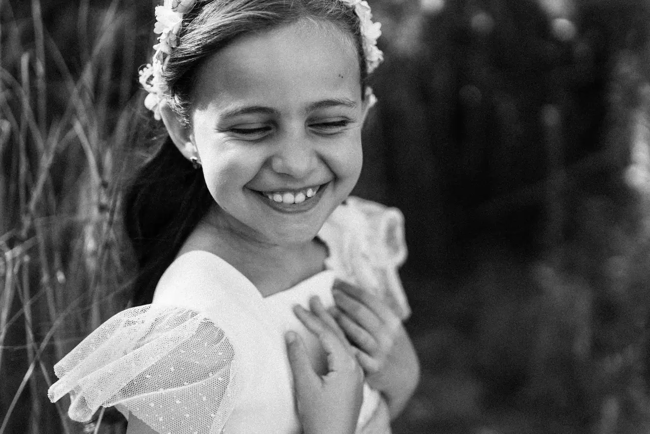 Fotografía de comunión: risa manos pecho, en blanco y negro