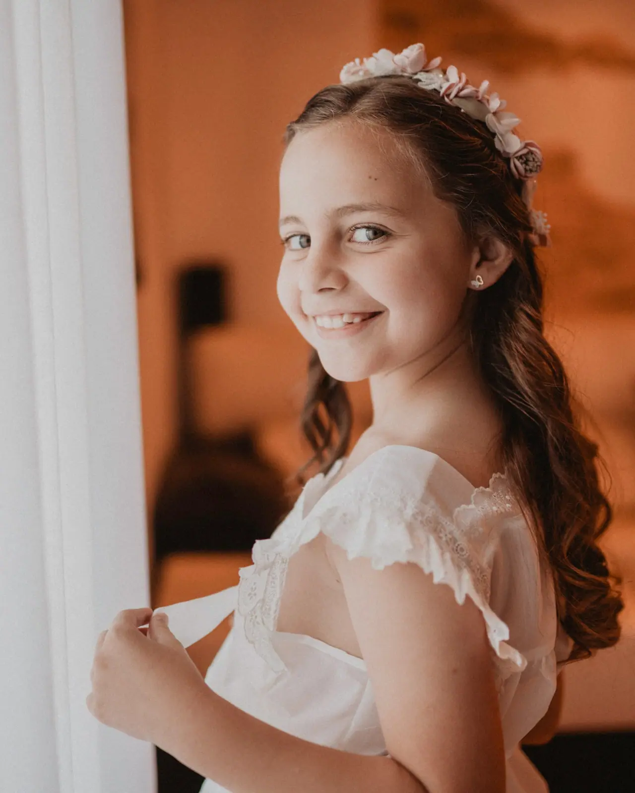 Fotografía de comunión: niña cortina sonrisa