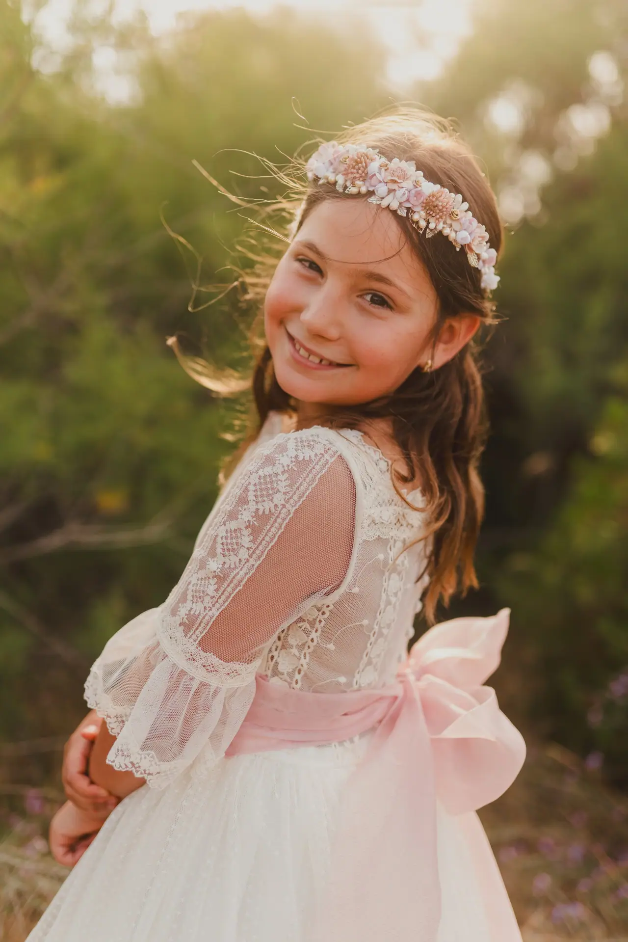 Fotografía de comunión: niña lazo rosa contraluz
