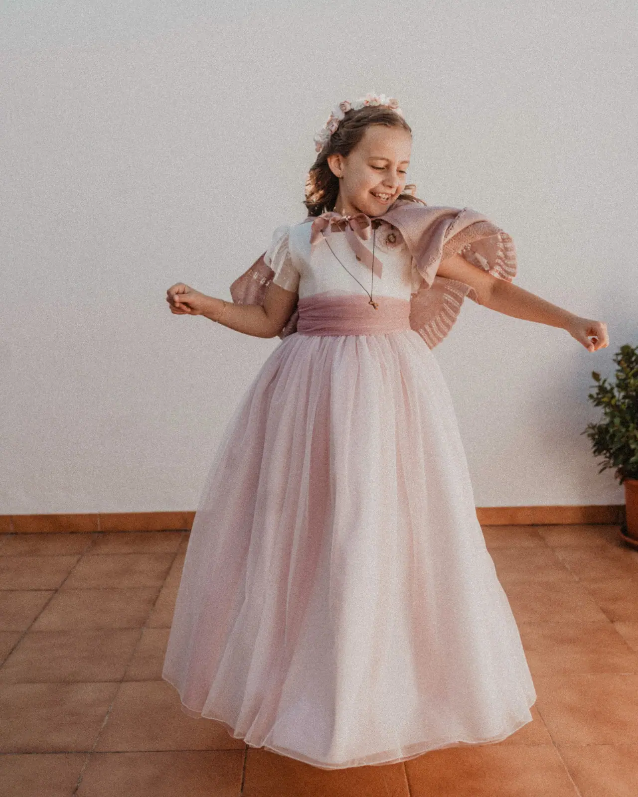 Niña girando con su vestido de comunión en casa