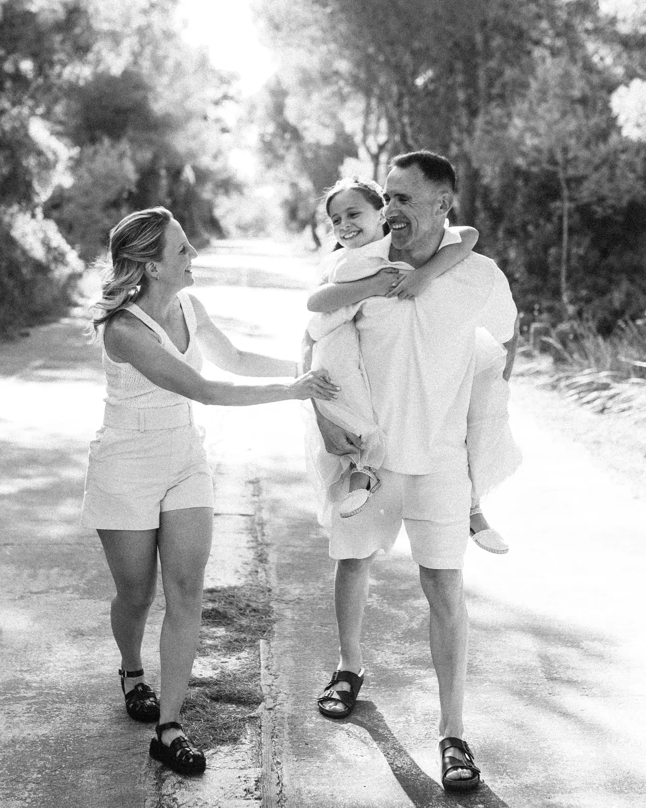 Familia paseando por un camino el día de la comunión, en blanco y negro