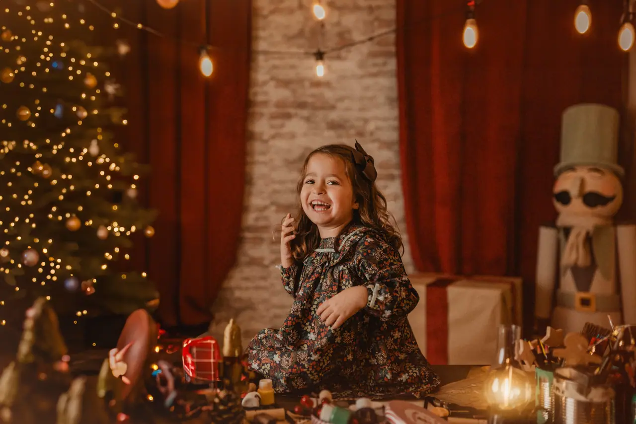 Sesión de fotos de Navidad en Benaguacil: niña risa mesa taller