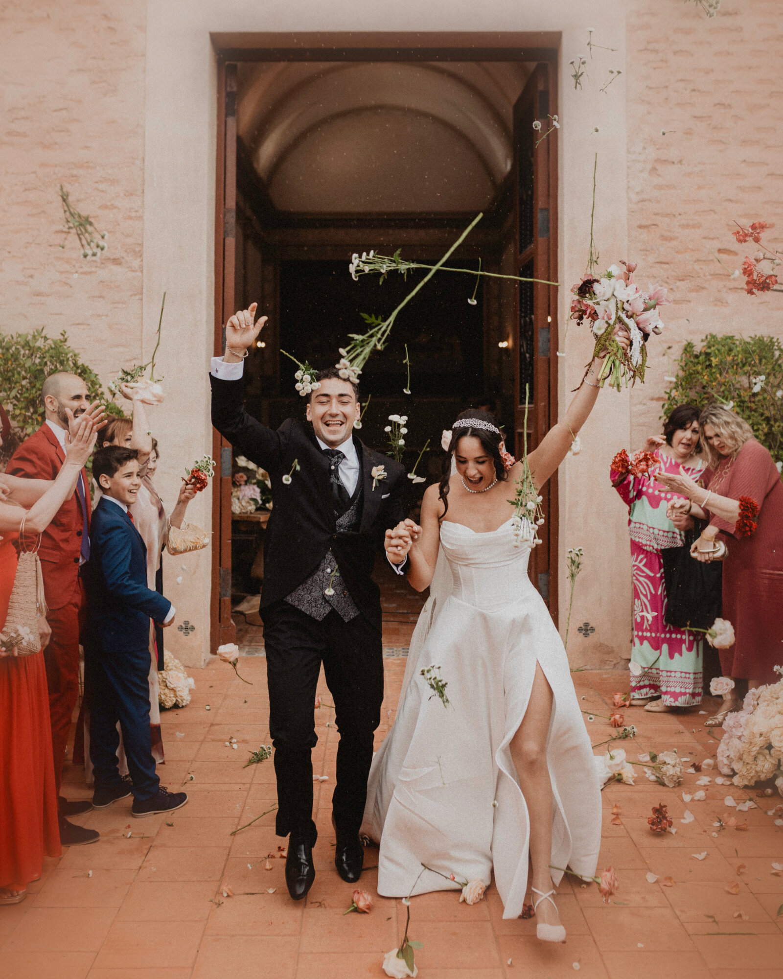 Novios saliendo de la ceremonia entre una lluvia de pétalos