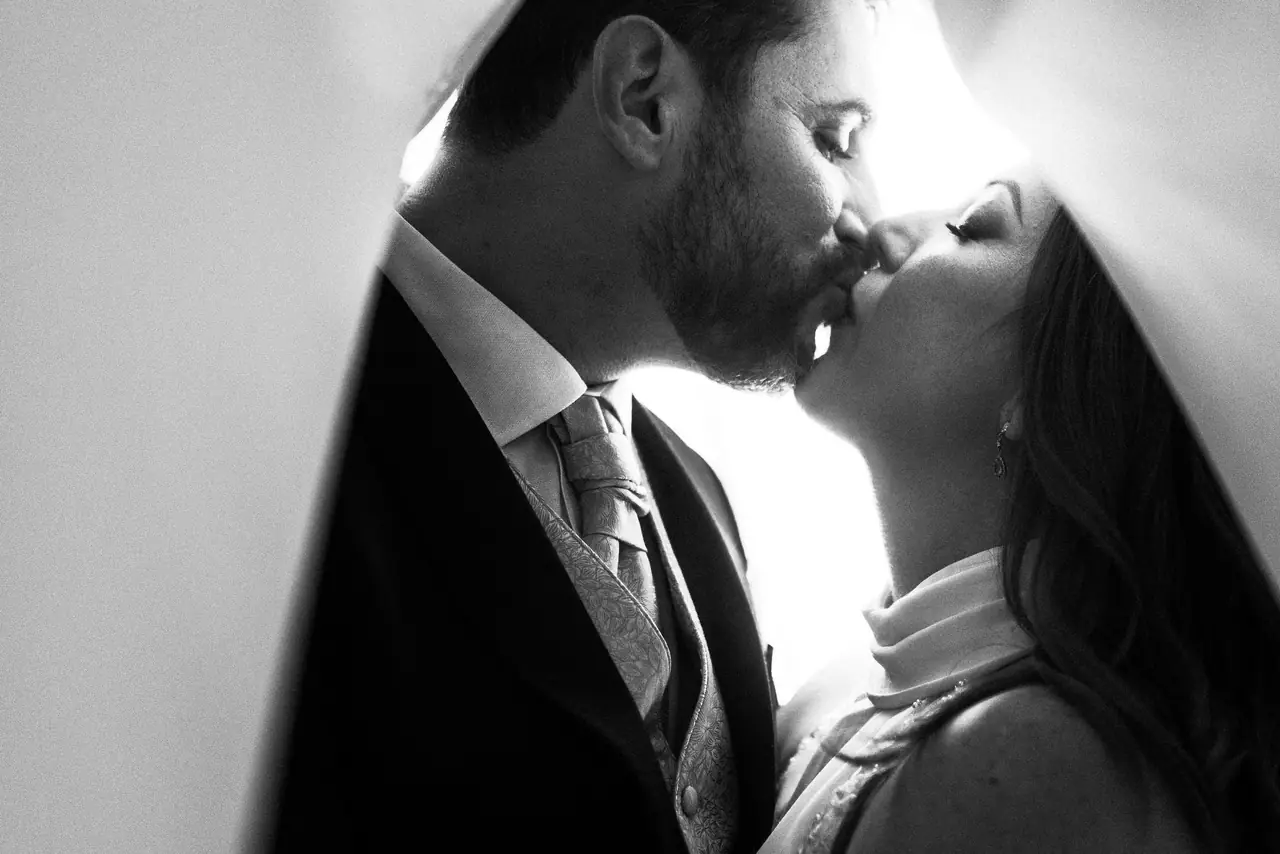 Sesión de postboda: beso bajo velo, en blanco y negro